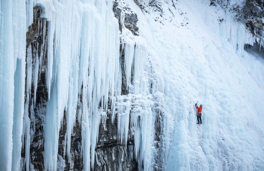 Person ice climbing on the frozen falls of Johnston Canyon